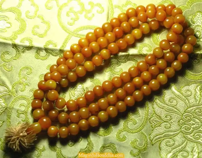 Large Tibetan mala in amber-colored resin.