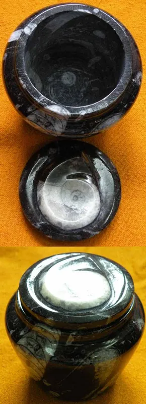Black stone urn with fossils.