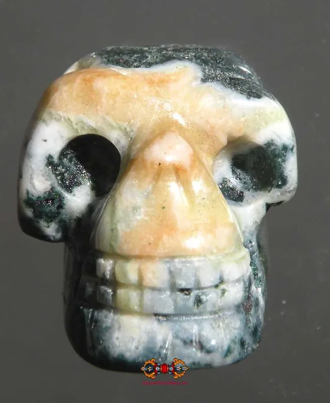 Small human skull carved from dark jade.