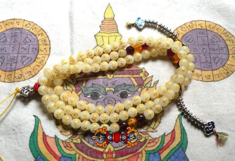 Buddhist rosary made of fluorescent Chinese Ye Ming Zhu stone engraved with mantra.
