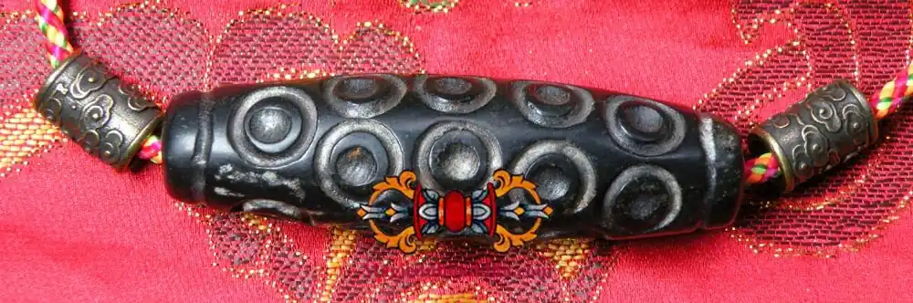 Large Tibetan Dzi Thogchag bead in magnetic black stone.