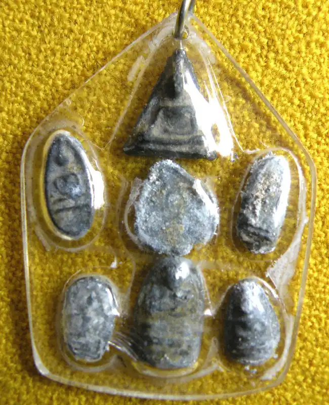 Collection of seven antique miniature Buddhist amulets made of lead.