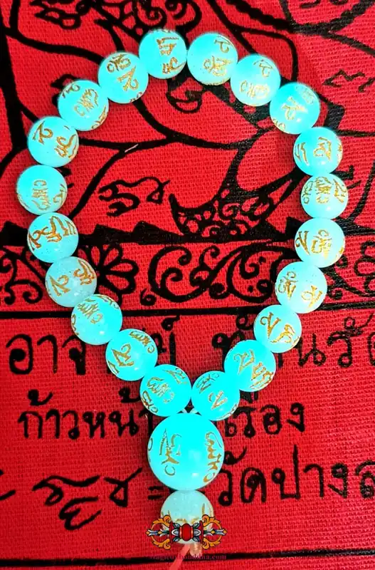 Buddhist wrist rosary made of Ye Ming Zhu stone engraved with mantra.