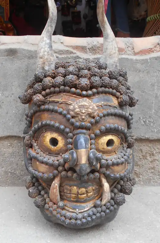 Masque de démon antique avec Elaeocarpus ganitrus