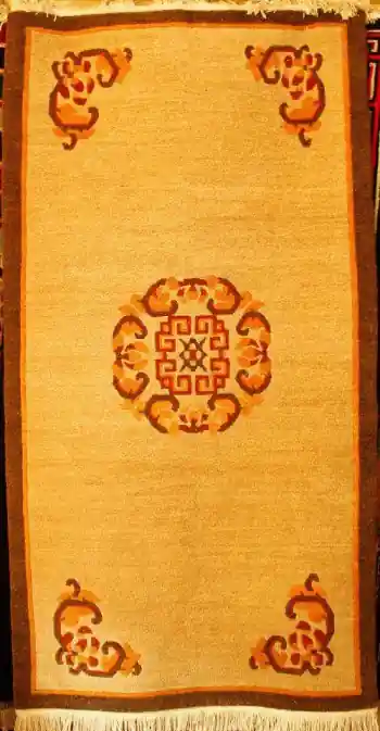 Tapis tibétain avec un motif de pièce au centre.