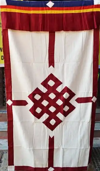 Le rideau blanc avec le nœud sans fin rouge