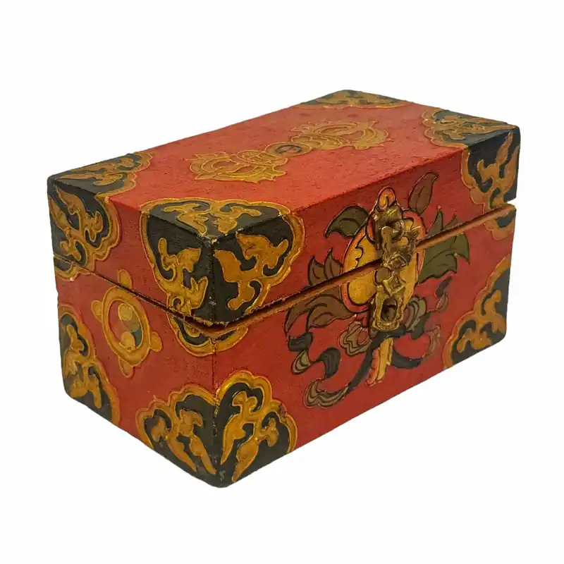 Coffre en bois tibétain avec des sculptures détaillées et des motifs peints