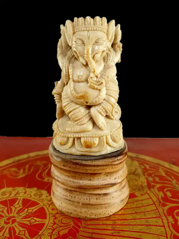 Ganesh bouddhiste sculpté dans de l’os de yak, sur un socle en bois.
